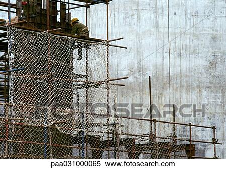 Stock Photography - Person working on scaffolding. Fotosearch
