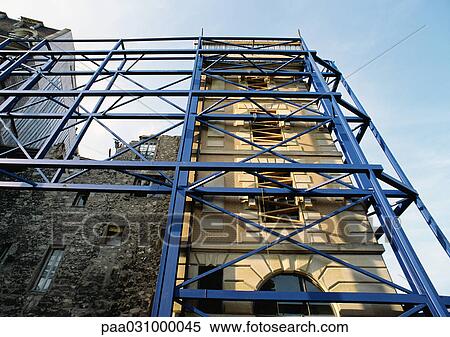 Scaffolding against building fronts, low angle view View Large Photo Image Stock Photography - Scaffolding against building fronts, low angle view. Fotosearch