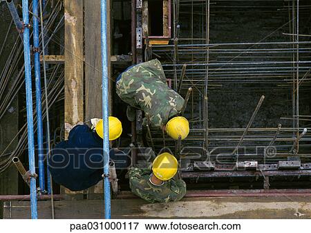 Three men wearing hard hats on construction site, elevated view View Large Photo Image Stock Photo - Three men wearing hard hats on construction site, elevated view. Fotosearch