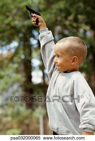 Boy holding toy gun, outside, rear view View Large Photo Image Stock Photography - Boy holding toy gun, outside, rear view. Fotosearch
