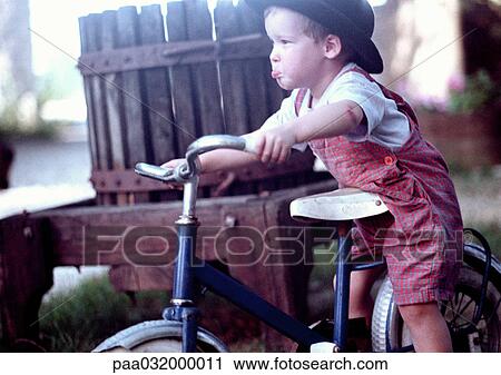 Stock Image - Boy on bike, side view. Fotosearch