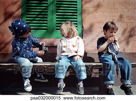 Stock Photography - Children sitting on bench. Fotosearch