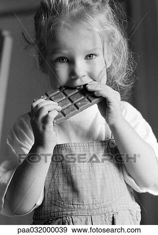 Stock Photo - Girl eating chocolate bar, b&w. Fotosearch