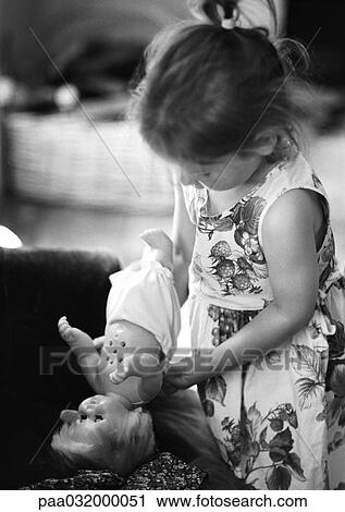 Stock Image - Girl holding baby doll, b&w. Fotosearch