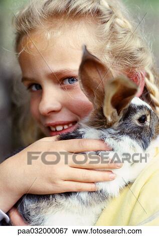 Girl hugging rabbit, close-up View Large Photo Image Stock Photo - Girl hugging rabbit, close-up. Fotosearch