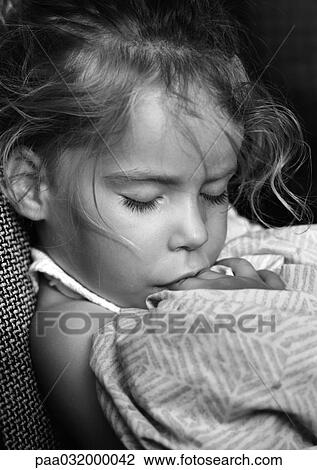 Stock Image - Girl sleeping with fingers in mouth, b&w. Fotosearch