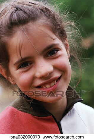 Stock Image - Girl smiling with head tilted, portrait. Fotosearch
