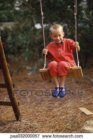 Little boy sitting on swing View Large Photo Image Stock Photo - Little boy sitting on swing. Fotosearch