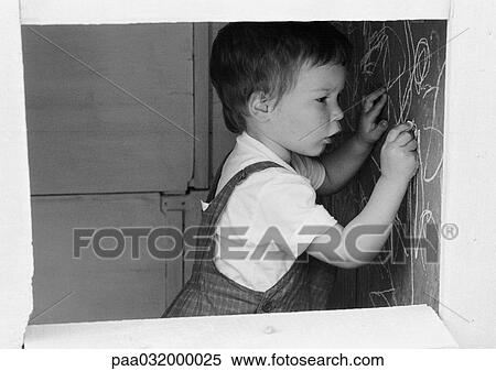 Stock Photography - Little boy writing on wall, side view, b&w. Fotosearch