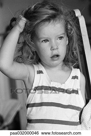 Stock Photograph - Little girl, hand on hair, b&w. Fotosearch
