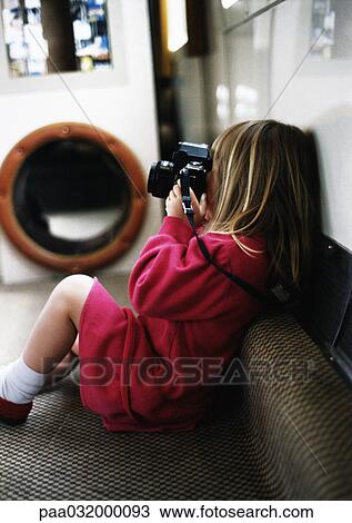 Little girl on sofa holding camera View Large Photo Image Stock Image - Little girl on sofa holding camera. Fotosearch