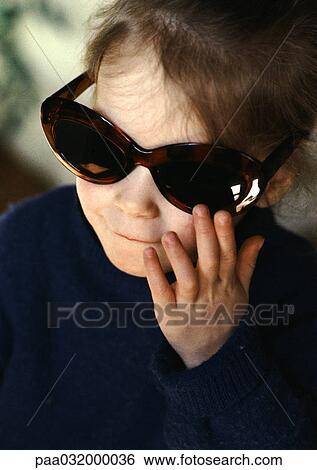 Little girl wearing oversized sunglasses View Large Photo Image Stock Photograph - Little girl wearing oversized sunglasses. Fotosearch