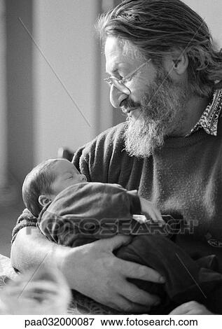 Stock Photo - Mature man holding baby, side view, b&w. Fotosearch