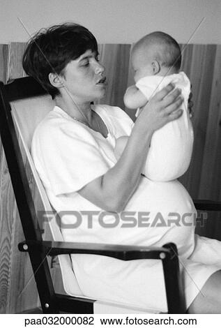 Stock Image - Pregnant woman holding baby, b&w. Fotosearch
