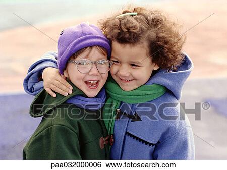 Stock Photograph - Two children hugging, smiling. Fotosearch