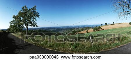 Stock Image - France, country road along fields, panoramic view. Fotosearch