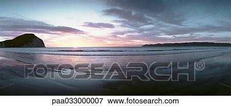 Stock Photo - New Zealand, beach at sunset, panoramic view. Fotosearch