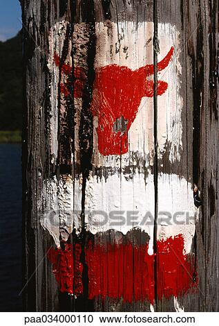Clipart - Bull's head symbol painted on wooden post. Fotosearch