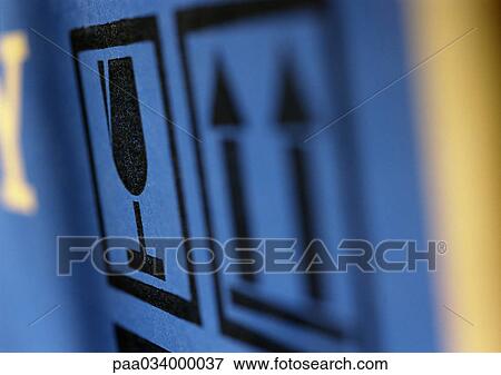 Stock Illustration - Glass and this way up symbols on box, extreme close-up, blurred. Fotosearch