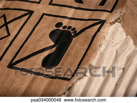 Stock Illustration - Warning sign with foot symbol on cardboard, close-up. Fotosearch