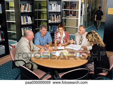 Stock Photo - Five people sitting in conference room, high angle view. Fotosearch
