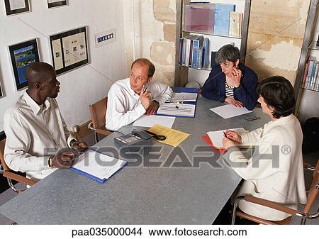 Picture - Four people in conference room, high angle view. Fotosearch