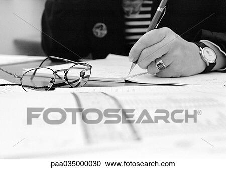 Stock Image - Hand holding pen, b&w. Fotosearch