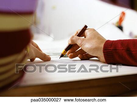 Stock Photo - Hand holding pen, close-up. Fotosearch