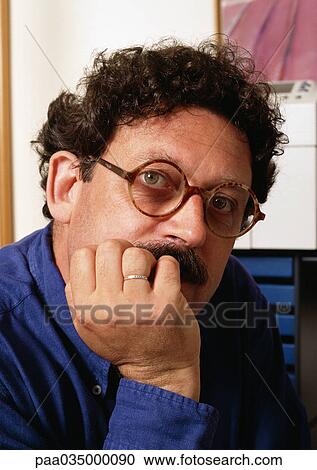 Stock Image - Man, hand under chin, portrait. Fotosearch