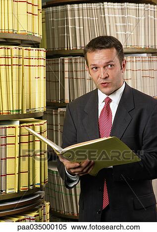 Man holding file, shelves in background View Large Photo Image Stock Photography - Man holding file, shelves in background. Fotosearch