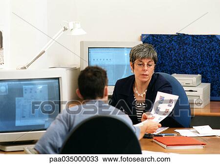 Man holding out document to woman in office View Large Photo Image Stock Image - Man holding out document to woman in office. Fotosearch
