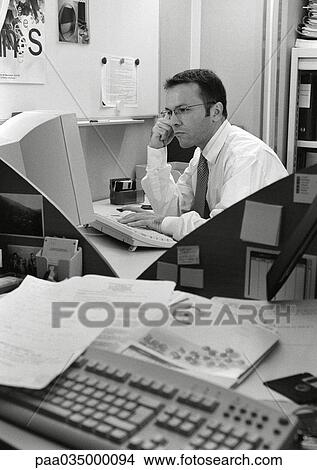 Picture - Man sitting in office, b&w. Fotosearch