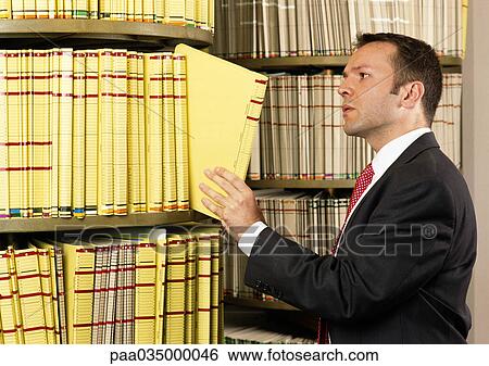 Stock Photograph - Man taking document from shelf. Fotosearch