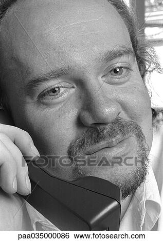 Stock Photograph - Man using phone, close-up, b&w. Fotosearch