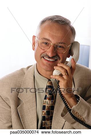 Picture - Man using phone, smiling, portrait. Fotosearch