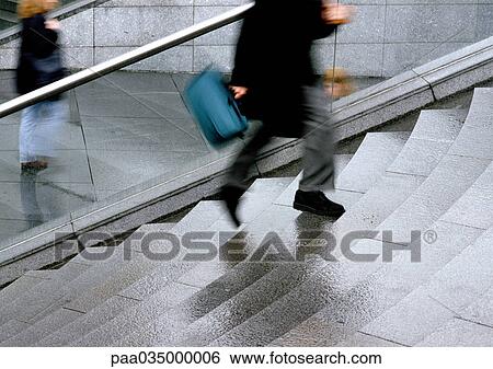 Stock Photograph - Person climbing stairs, low section, blurred motion. Fotosearch