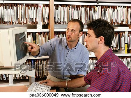 Two men sitting at computer screen View Large Photo Image Stock Photo - Two men sitting at computer screen. Fotosearch