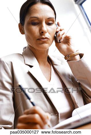 Woman holding cell phone, low angle view View Large Photo Image Stock Photo - Woman holding cell phone, low angle view. Fotosearch