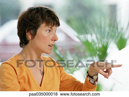 Stock Photo - Woman pointing finger, portrait. Fotosearch
