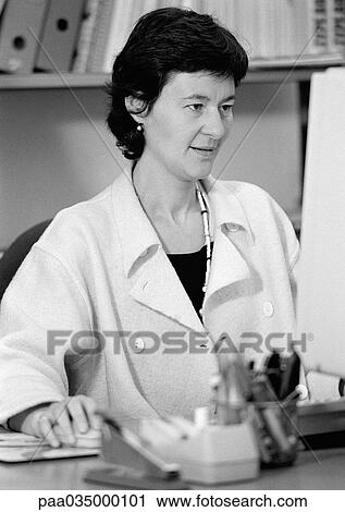 Stock Image - Woman sitting at computer, b&w. Fotosearch