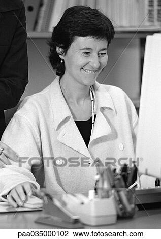 Stock Image - Woman sitting at computer, b&w. Fotosearch