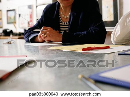 Woman sitting at desk, partial view View Large Photo Image Stock Image - Woman sitting at desk, partial view. Fotosearch