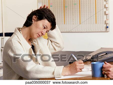Woman sitting at desk, writing View Large Photo Image Stock Photo - Woman sitting at desk, writing. Fotosearch