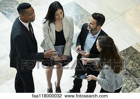 Business people discussing in hotel lobby View Large Photo Image Stock Image - Business people discussing in hotel lobby. Fotosearch