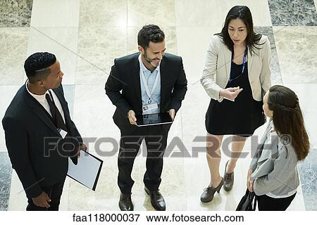 Business people discussing in hotel lobby View Large Photo Image Stock Photo - Business people discussing in hotel lobby. Fotosearch