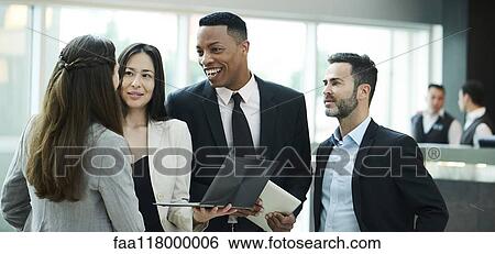 Stock Photograph - Business people discussing in hotel lobby. Fotosearch