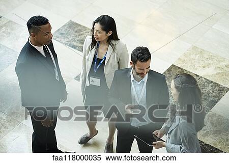 Stock Photography - Business people discussing in hotel lobby. Fotosearch