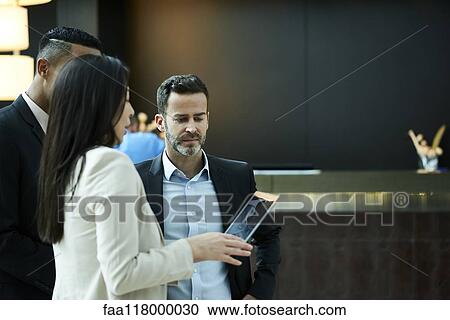 Business people discussing on laptop in hotel lobby View Large Photo Image Stock Image - Business people discussing on laptop in hotel lobby. Fotosearch