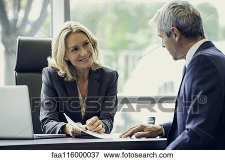 Stock Photo - Business people discussing paperwork. Fotosearch