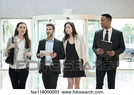 Business people discussing while walking in hotel lobby View Large Photo Image Stock Image - Business people discussing while walking in hotel lobby. Fotosearch